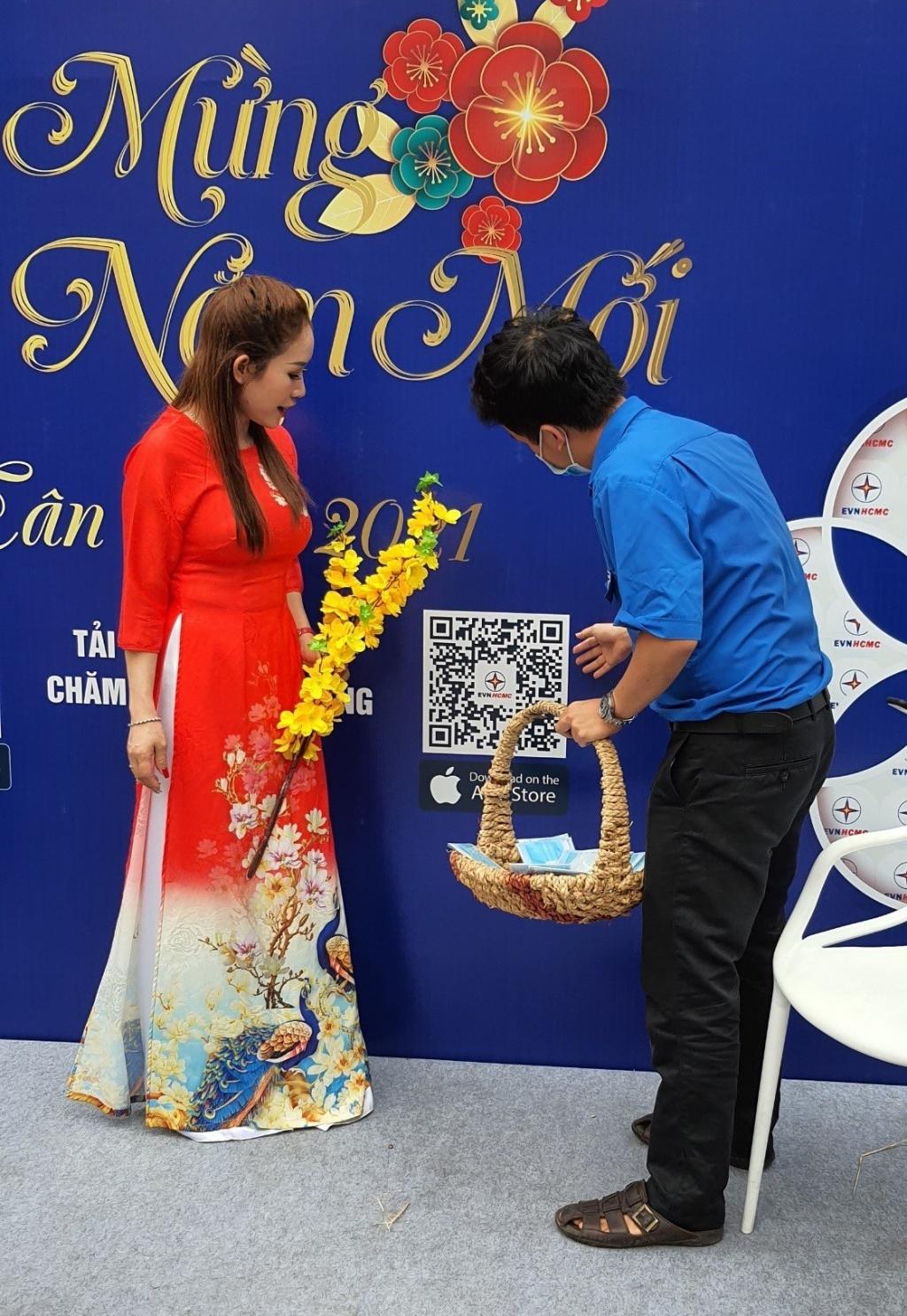 Các bạn đoàn viên đang hướng dẫn người dân cài đặt ứng dụng Chăm sóc khách hàng EVNHCMC trên thiết bị di động